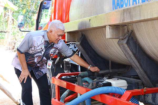 Kepala OJK DIY, Eko Yulianto membuka kran tanki air bersih untuk masyarakat Rongkop, Kabupaten Gunungkidul.